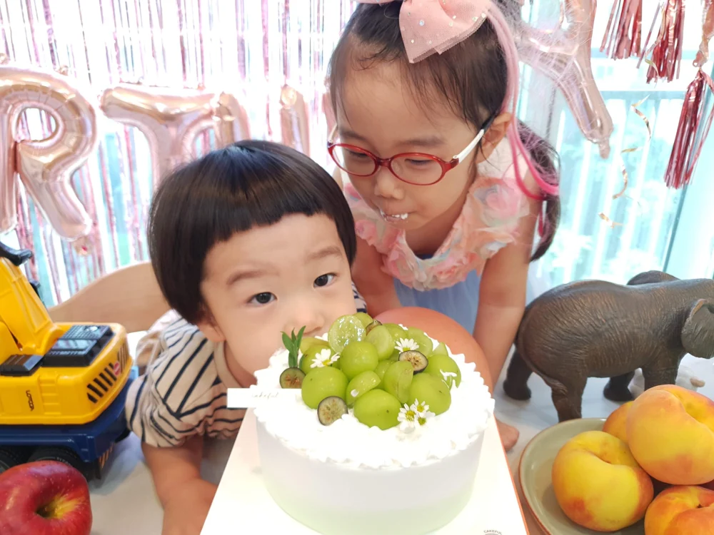 생일 케이크 앞에서 함께 웃는 아이들